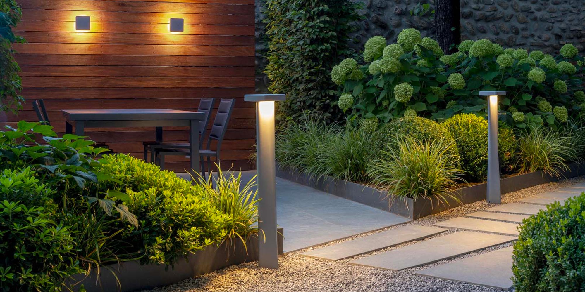 Two architectural bollards installed on a patio pathway